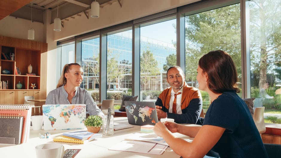 Three diverse professionals collaborate in a bright, modern workspace.