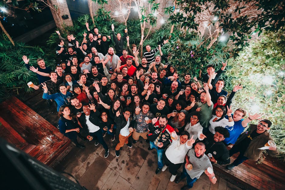 A large group of joyful people posing under string lights in a garden setting. Perfect for joyful and community themes.